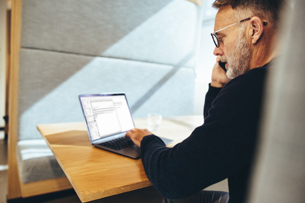 A businessman in a call, working on his laptop.